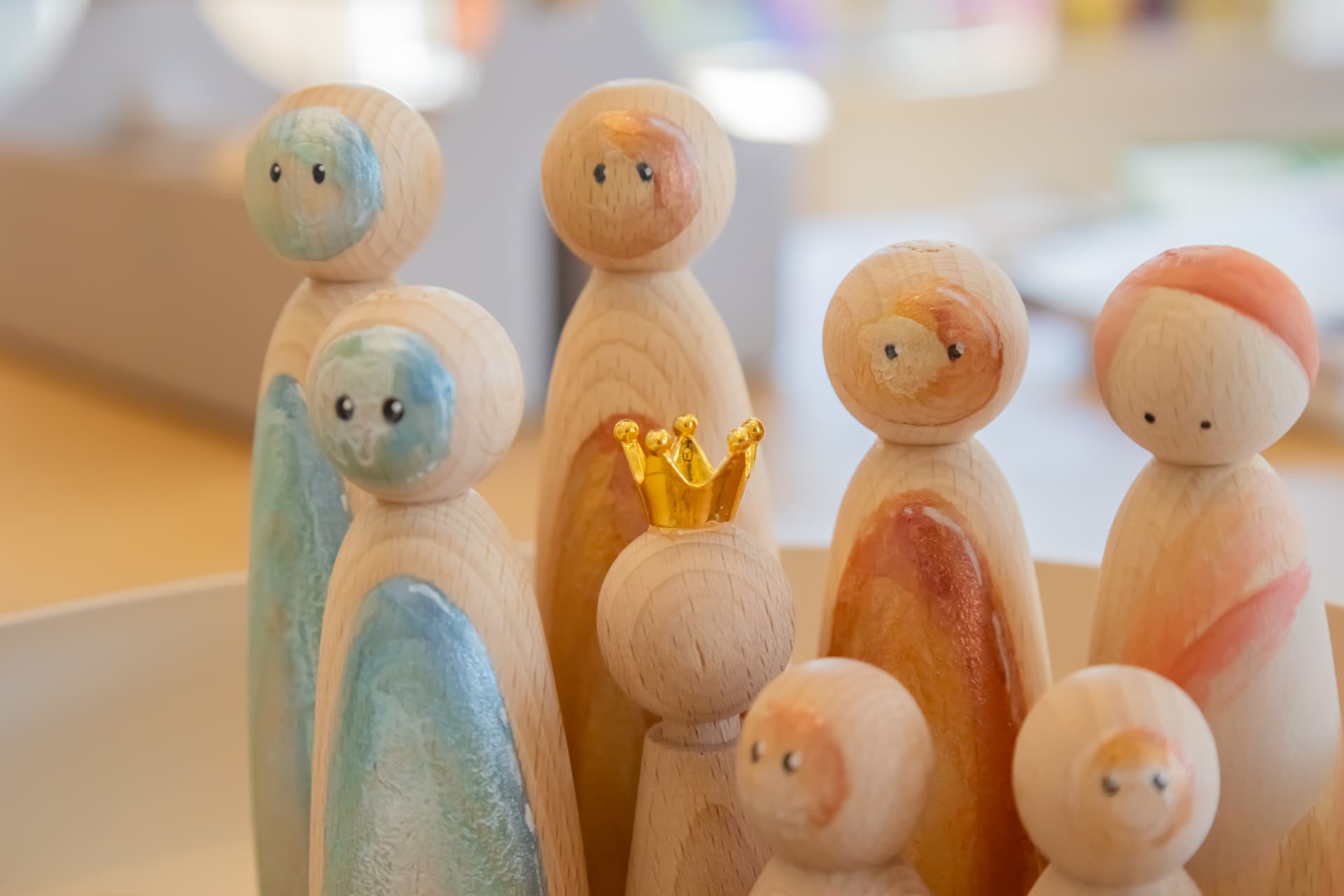 Houten poppetjes die een familie voorstellen, met een gouden kroon als symbool van eigen kracht